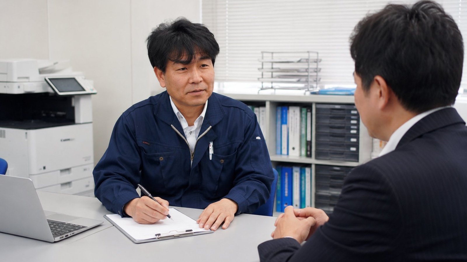 打合せでコピー機の入れ替えを相談する雷都コピーのサービスエンジニア